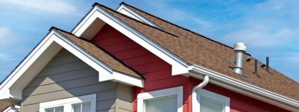 house with tan and red siding and brown roof