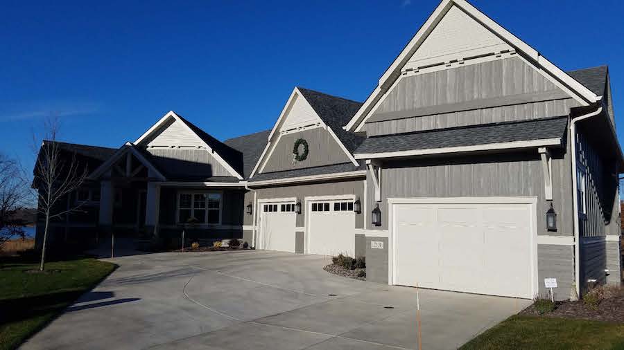 home with three garage doors and siding